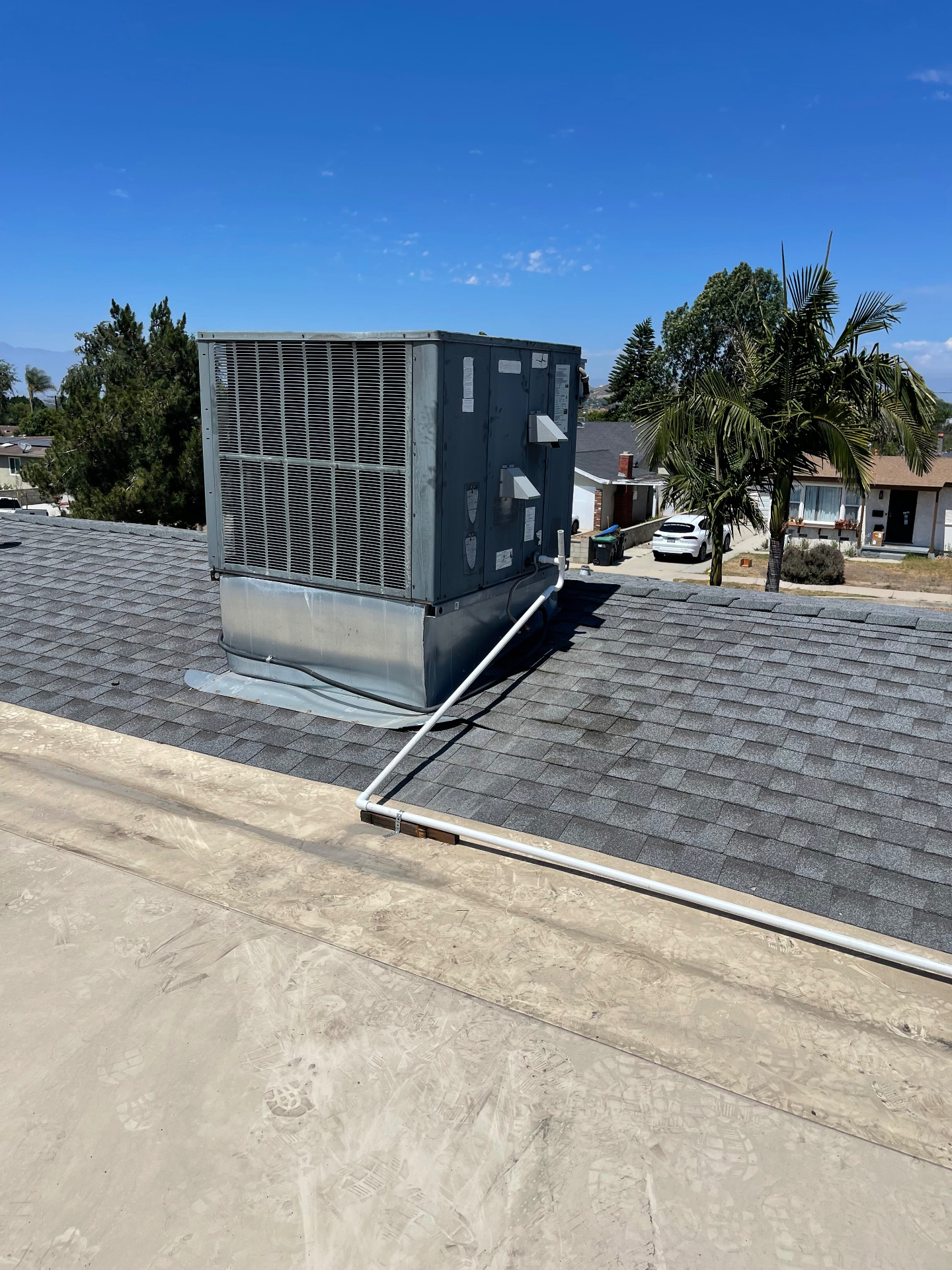 Rooftop package unit install with new flashing on shingle roof